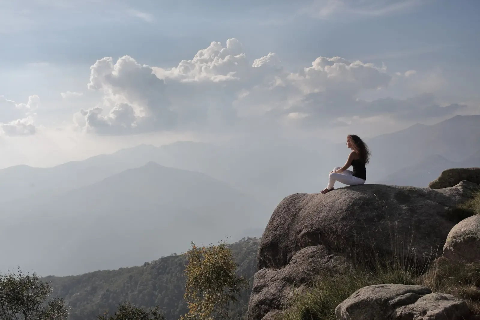 Person contemplating the sunrise in the mountains