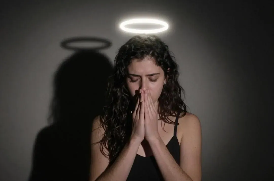 Persona en oración con halo y sombra, insinuando doble vida o pasiones secretas, propia de la mística infrasexual.